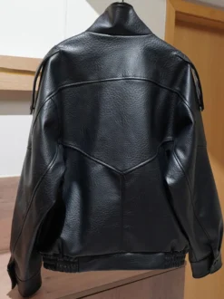 Veste bomber vintage en similicuir noir et marron uni coupe décontractée taille élastiquée.