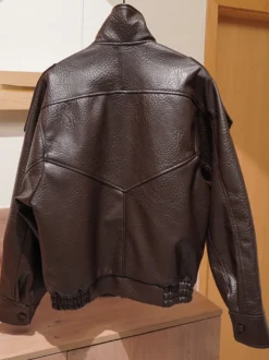 Veste bomber vintage en similicuir noir et marron uni coupe décontractée taille élastiquée.
