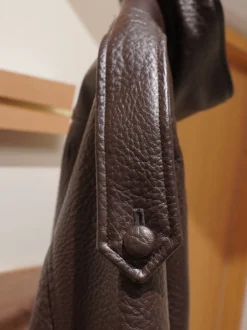 Veste bomber vintage en similicuir noir et marron uni coupe décontractée taille élastiquée.